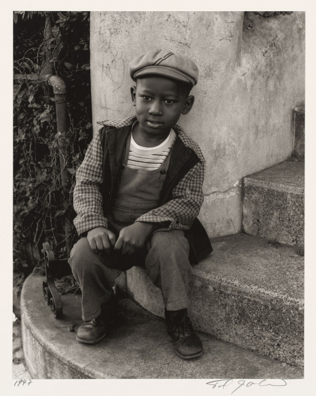 An African-American child sitting on concrete steps