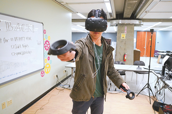 Austin Wangyu ’21 tries out a virtual reality simulation in Moffitt during a Makerspace event. 