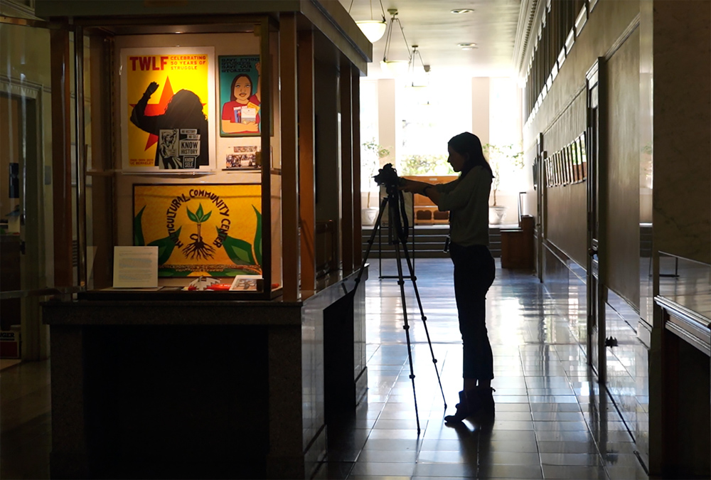 Work+Learn student Sofia Daniels, a video intern, films parts of an exhibit in the Brown Galley in Doe Library in August 2019. (Photo by Jami Smith for the UC Berkeley Library)