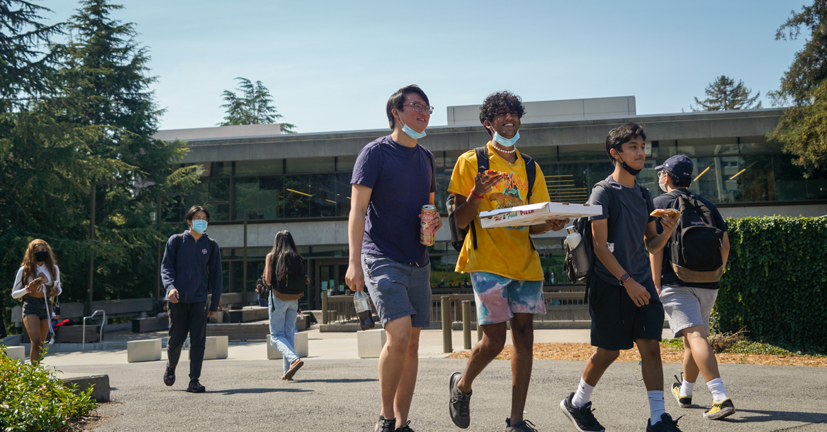 Students walk by Moffitt Library with pizza on a sunny Sept. 21, 2021. (Photo by Jami Smith for the UC Berkeley Library)